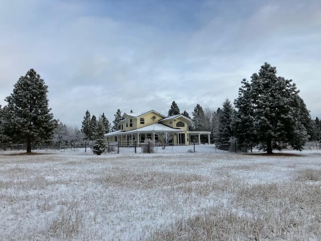 view of front of house featuring covered porch and fence