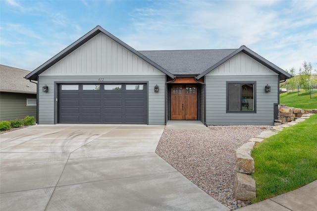 412 White Fox Run, Polson, MT 59860 - view of front of property featuring concrete driveway, board and batten siding, a garage, and a shingled roof
