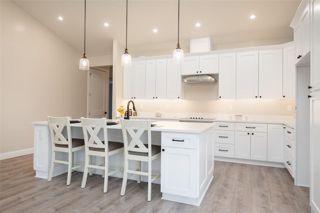 412 White Fox Run, Polson, MT 59860 - kitchen featuring an island with sink, light wood-style floors, light countertops, white cabinetry, and recessed lighting