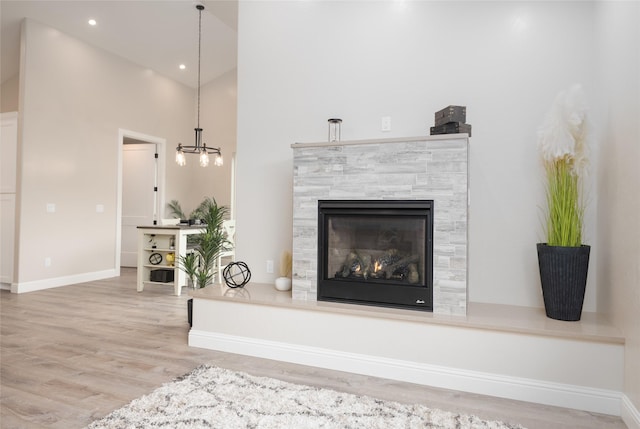 412 White Fox Run, Polson, MT 59860 - detailed view of a tiled fireplace, wood finished floors, a chandelier, baseboards, and recessed lighting