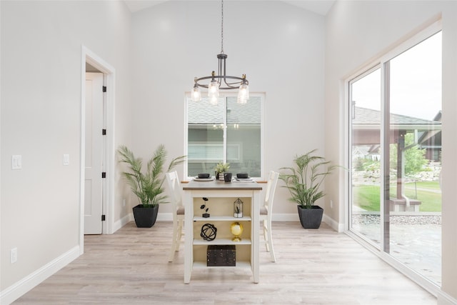412 White Fox Run, Polson, MT 59860 - dining area featuring a chandelier, light wood finished floors, plenty of natural light, baseboards, and a towering ceiling