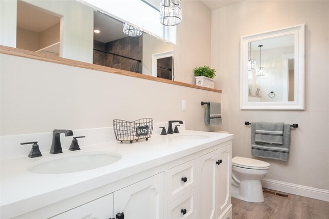 412 White Fox Run, Polson, MT 59860 - bathroom with toilet, wood finished floors, double vanity, a shower, and a chandelier