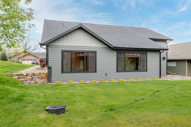 412 White Fox Run, Polson, MT 59860 - rear view of property with board and batten siding, a yard, roof with shingles, and an outdoor fire pit