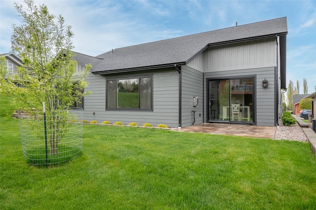 412 White Fox Run, Polson, MT 59860 - back of property featuring roof with shingles, a lawn, and a patio area