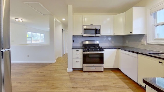 1240 Cannon St, Helena, MT 59601 - kitchen with stainless steel appliances, white cabinets, light wood-style floors, healthy amount of natural light, and recessed lighting