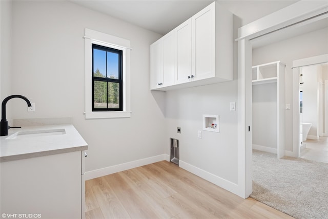 washroom with cabinet space, electric dryer hookup, washer hookup, and light wood-style flooring
