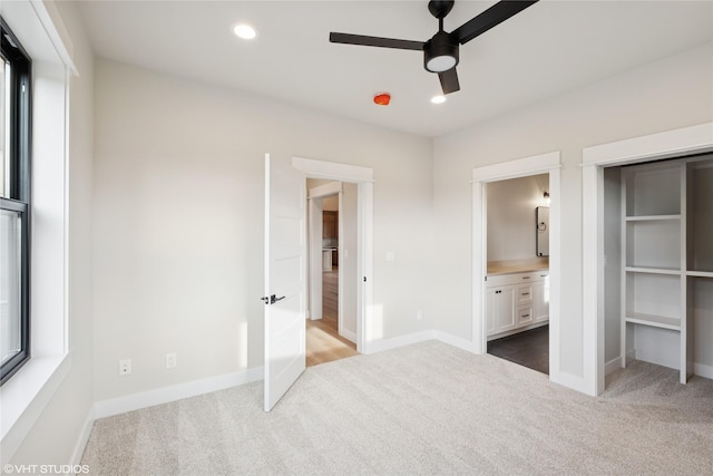 unfurnished bedroom featuring carpet, baseboards, ensuite bath, recessed lighting, and a ceiling fan