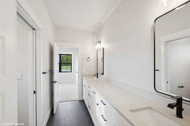 bathroom with double vanity and baseboards