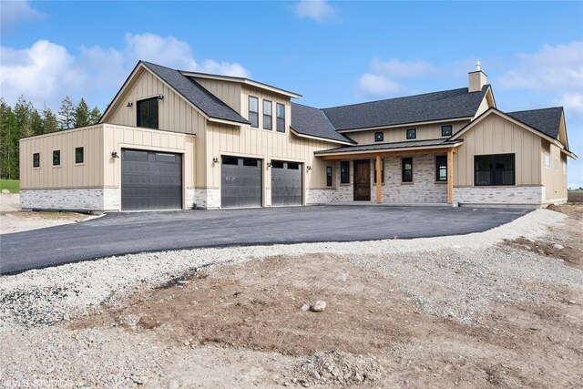 168 Wood Ridge Dr, Columbia Falls, MT 59912 - modern farmhouse style home featuring board and batten siding, a shingled roof, and covered porch