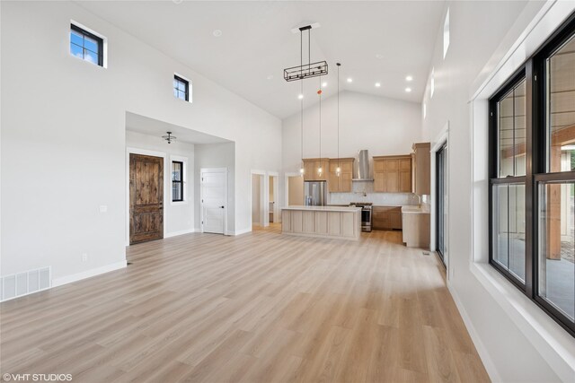 168 Wood Ridge Dr, Columbia Falls, MT 59912 - unfurnished living room with high vaulted ceiling, light wood-style floors, and recessed lighting