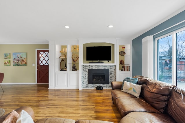 4003 Thomas Pl, Missoula, MT 59803 - living room featuring crown molding, wood finished floors, baseboards, built in shelves, and a fireplace