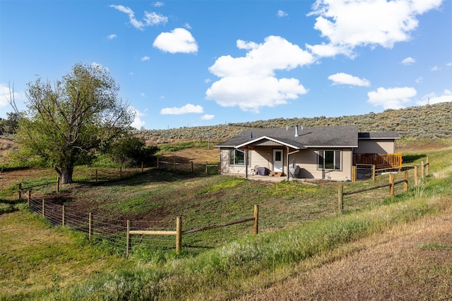 688 Black Horse Trl, Stevensville, MT 59870 - view of front of home featuring a fenced backyard, a patio area, and a rural view