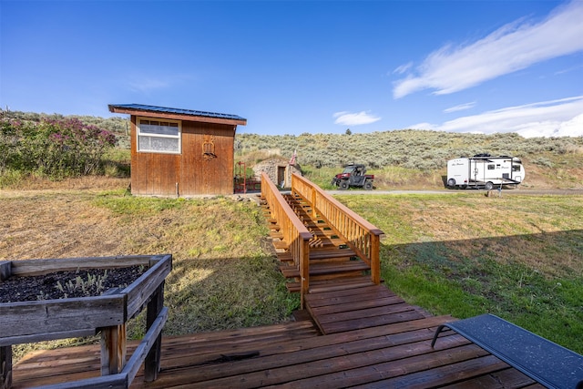 688 Black Horse Trl, Stevensville, MT 59870 - wooden deck featuring stairs, a lawn, and an outdoor structure