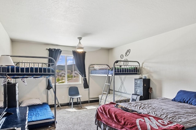 carpeted bedroom featuring baseboards and a textured ceiling