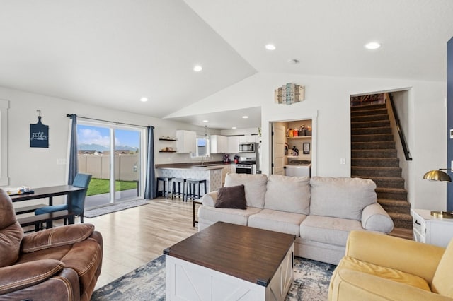 living area featuring stairs, vaulted ceiling, recessed lighting, and light wood-type flooring
