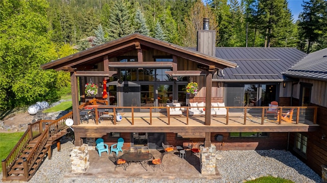 32220 Tamarack Dr, Bigfork, MT 59911 - rear view of house with a chimney, stairs, a patio, a standing seam roof, and a deck