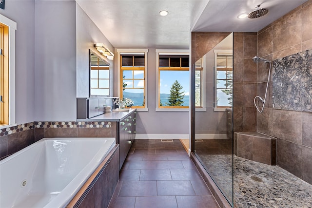 32220 Tamarack Dr, Bigfork, MT 59911 - full bathroom with tiled shower, a jetted tub, vanity, and tile patterned flooring