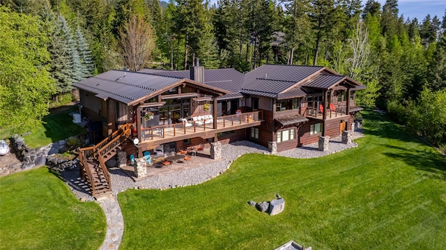 32220 Tamarack Dr, Bigfork, MT 59911 - rear view of house with a standing seam roof, stairway, a patio area, a deck, and a metal roof