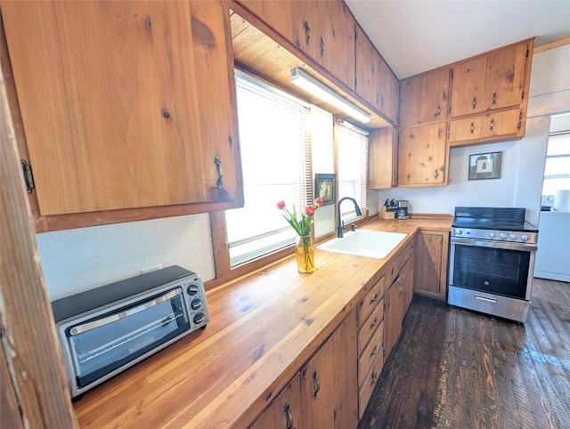 403 Mission St, Stevensville, MT 59870 - kitchen featuring electric range, a sink, wooden counters, washer / dryer, and brown cabinetry