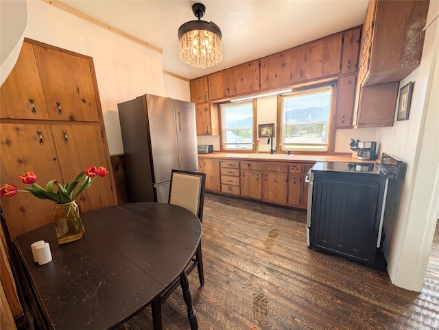 403 Mission St, Stevensville, MT 59870 - kitchen featuring freestanding refrigerator, a chandelier, dark wood-style flooring, a sink, and range
