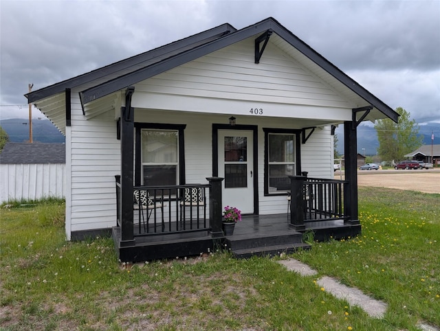403 Mission St, Stevensville, MT 59870 - shotgun-style home featuring a porch and a front lawn