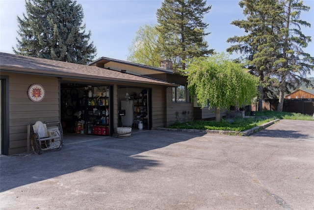38 Lakeside Ave, Lakeside, MT 59922 - back of property featuring asphalt driveway, a chimney, and a garage
