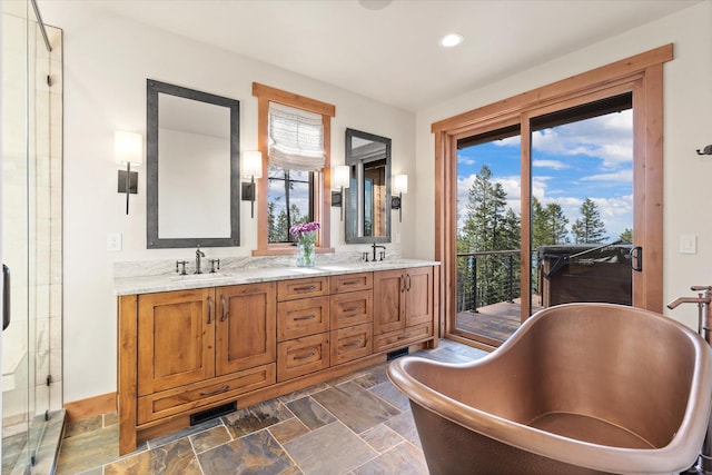 66 Elk Highlands Dr, Whitefish, MT 59937 - bathroom with stone finish flooring, double vanity, a freestanding tub, recessed lighting, and a stall shower