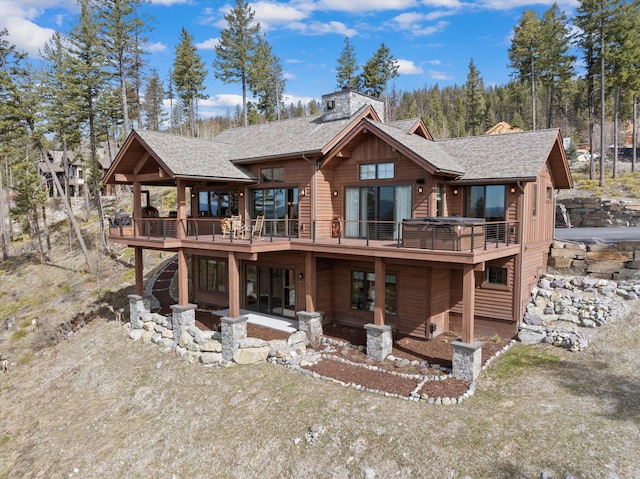 66 Elk Highlands Dr, Whitefish, MT 59937 - back of property with a wooden deck, a chimney, and roof with shingles