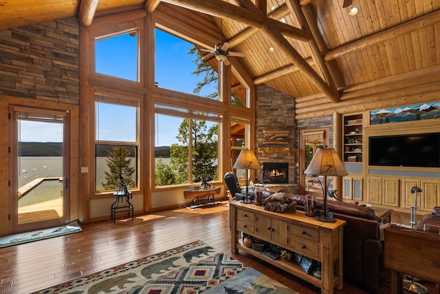 51605 Lake Mary Ronan Rd, Proctor, MT 59929 - living room with high vaulted ceiling, hardwood / wood-style flooring, a stone fireplace, a wooden ceiling with exposed beams, and rustic walls