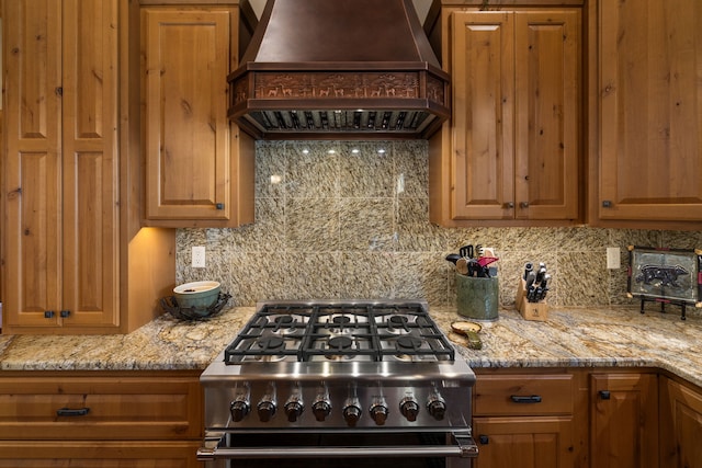 51605 Lake Mary Ronan Rd, Proctor, MT 59929 - kitchen with custom range hood, stove, decorative backsplash, and light stone countertops