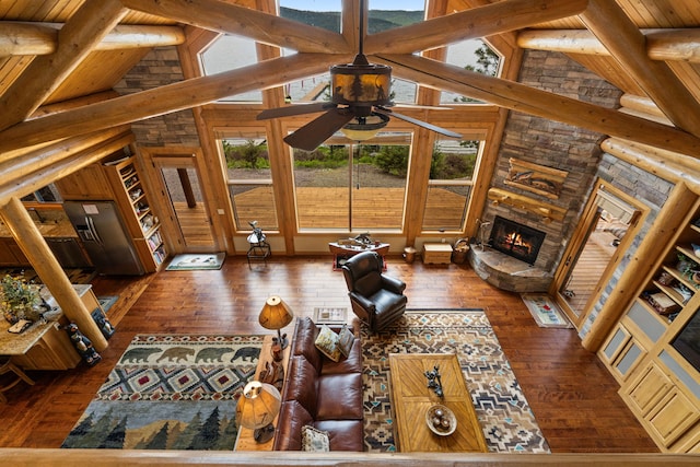 51605 Lake Mary Ronan Rd, Proctor, MT 59929 - living room featuring wood-type flooring, a ceiling fan, a fireplace, a wooden ceiling with exposed beams, and high vaulted ceiling