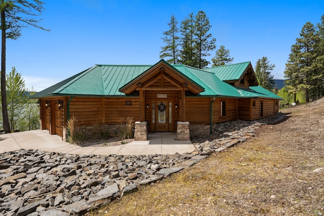 51605 Lake Mary Ronan Rd, Proctor, MT 59929 - chalet / cabin with concrete driveway, a metal roof, a garage, and log veneer siding