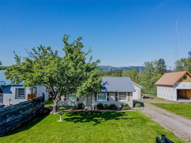 514 W 1st St, Libby, MT 59923 - view of front of house with driveway, a mountain view, metal roof, and an outbuilding