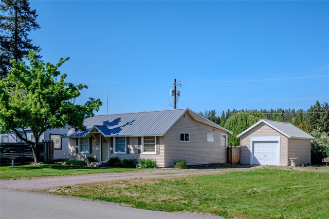514 W 1st St, Libby, MT 59923 - ranch-style home featuring a detached garage, an outdoor structure, asphalt driveway, and metal roof
