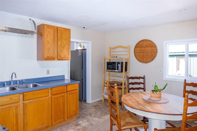 514 W 1st St, Libby, MT 59923 - kitchen with a sink, appliances with stainless steel finishes, brown cabinets, and dark countertops
