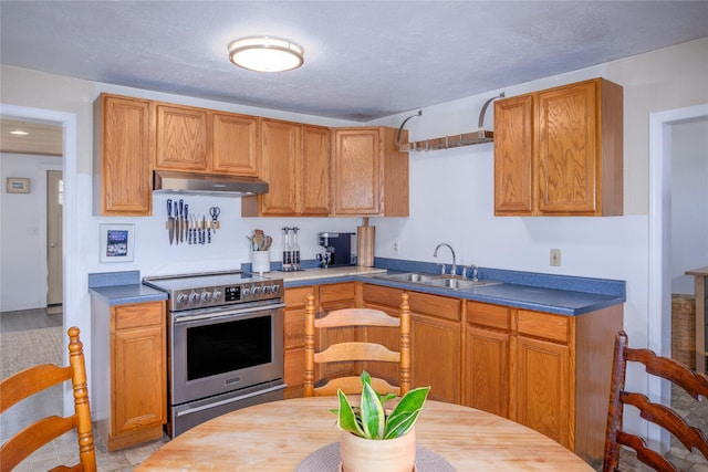 514 W 1st St, Libby, MT 59923 - kitchen featuring electric stove, under cabinet range hood, a sink, a textured ceiling, and brown cabinets