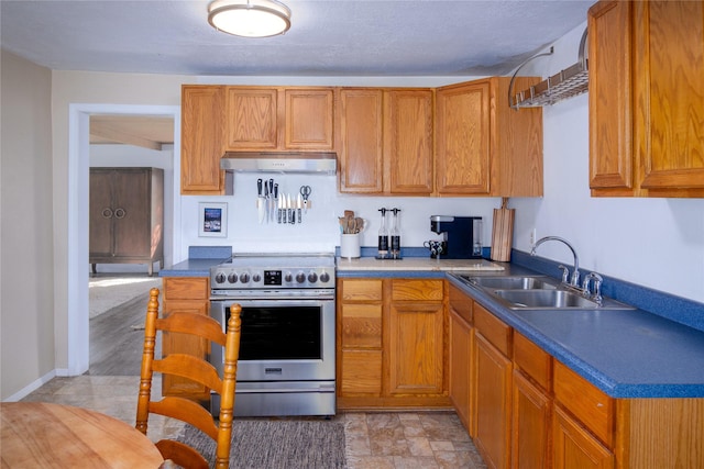 514 W 1st St, Libby, MT 59923 - kitchen with stainless steel range with electric cooktop, a sink, under cabinet range hood, brown cabinetry, and dark countertops