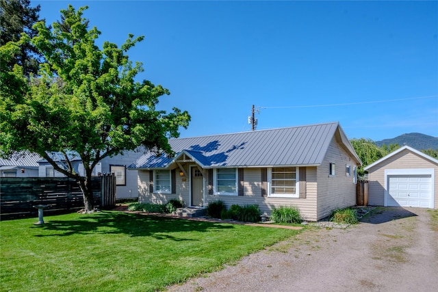 514 W 1st St, Libby, MT 59923 - view of front of house with dirt driveway, an outbuilding, a detached garage, a mountain view, and metal roof