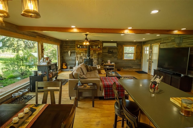35966 Dublin Gulch Rd, Saint Ignatius, MT 59865 - living room featuring a wood stove, a wall mounted air conditioner, light wood-type flooring, wood walls, and recessed lighting