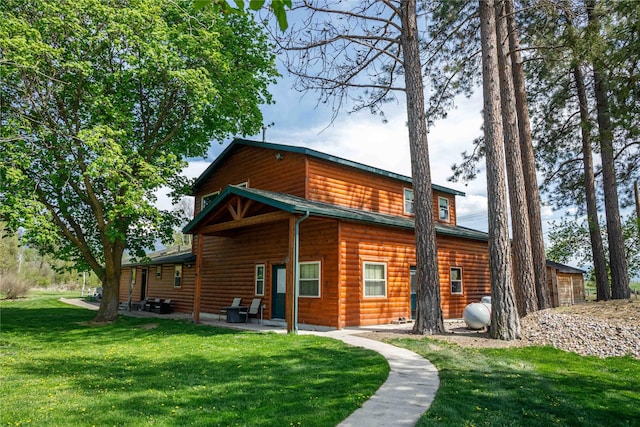35966 Dublin Gulch Rd, Saint Ignatius, MT 59865 - back of property featuring faux log siding, a lawn, and a patio