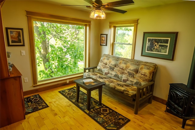 35966 Dublin Gulch Rd, Saint Ignatius, MT 59865 - sitting room featuring a wood stove, a ceiling fan, wood finished floors, and baseboards
