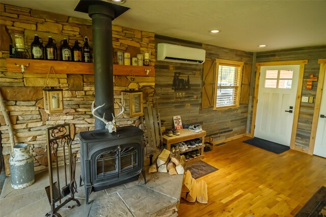35966 Dublin Gulch Rd, Saint Ignatius, MT 59865 - living room with a wood stove, a wall mounted air conditioner, wood finished floors, recessed lighting, and wooden walls
