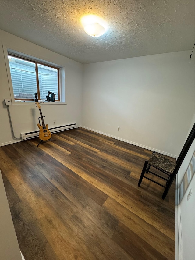 4900 Clearview Way, Missoula, MT 59803 - spare room with a baseboard heating unit, dark wood-style flooring, a textured ceiling, and baseboards