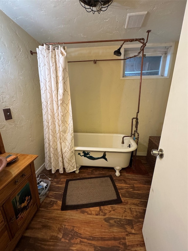 4900 Clearview Way, Missoula, MT 59803 - bathroom featuring a freestanding tub, wood finished floors, a textured wall, and curtained shower