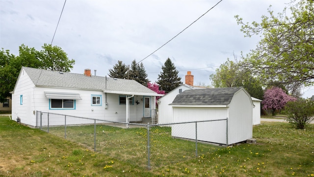 521 Buck St, Stevensville, MT 59870 - rear view of house featuring a shed, an outdoor structure, a shingled roof, and a chimney