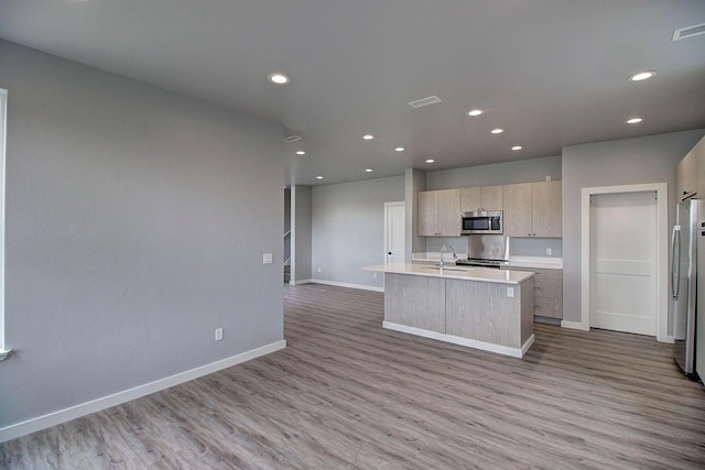 405 Trailview Way, Whitefish, MT 59937 - kitchen featuring appliances with stainless steel finishes, wood finished floors, an island with sink, light countertops, and modern cabinets