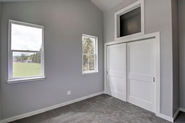 405 Trailview Way, Whitefish, MT 59937 - unfurnished bedroom featuring dark colored carpet, lofted ceiling, baseboards, and a closet