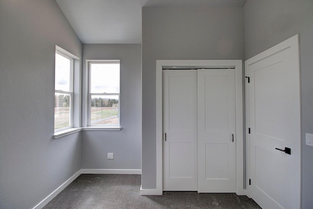 405 Trailview Way, Whitefish, MT 59937 - unfurnished bedroom with dark colored carpet, baseboards, multiple windows, and a closet