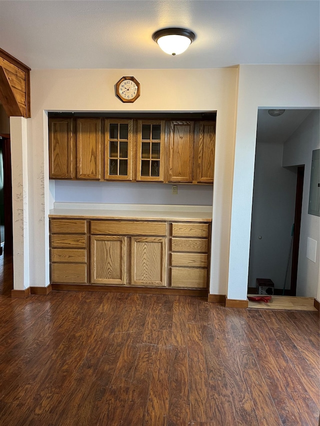 156 Clary Ave W, Geraldine, MT 59446 - kitchen featuring brown cabinetry, light countertops, glass insert cabinets, and dark wood finished floors