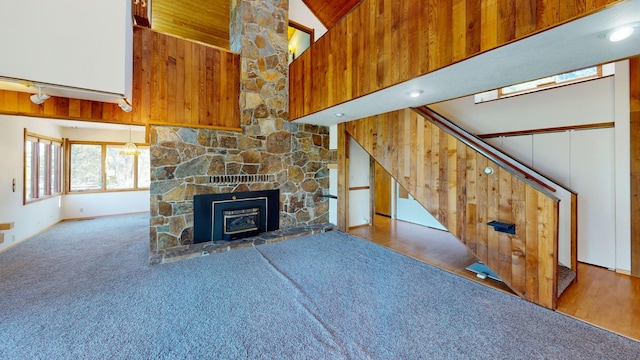 1487 Lion Mountain Dr, Whitefish, MT 59937 - unfurnished living room with a high ceiling, carpet, stairway, and a stone fireplace